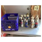Various tan & cream spray paint cans in plastic crate