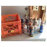Assorted gold and chrome spray paint cans in plastic crate