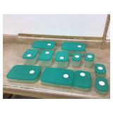 Various green Tupperware containers with lids in storage tote